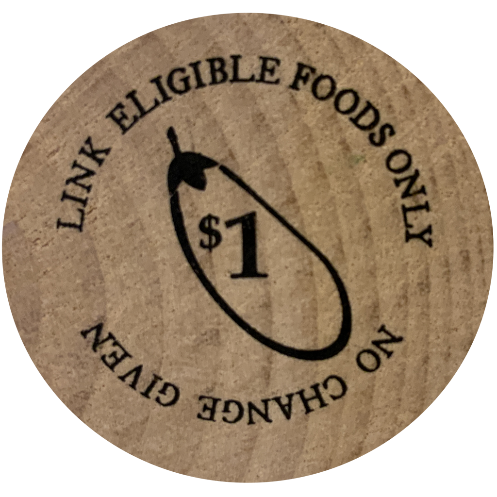 A wooden token stamped with an image of an eggplant. Text reads: "No change given, Link eligible foods only"